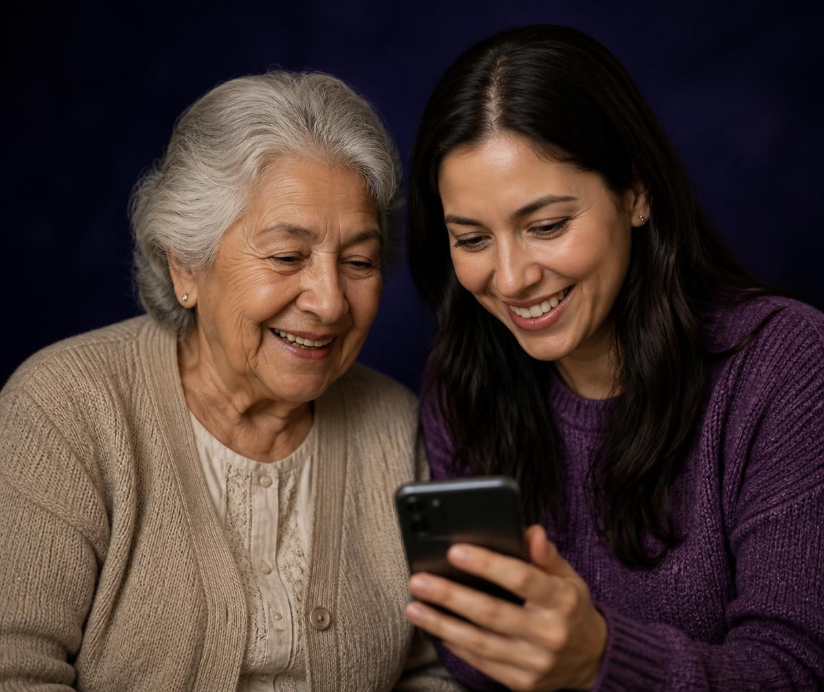 Una cuidadora y su madre miran juntas el teléfono con Clara